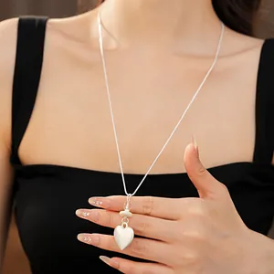Detailed view of a silver-tone heart pendant necklace featuring glass and stone beads