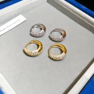 Detailopname van 14K vergulde oorringen met sprankelende pavé gezette zirkonia steentjes.