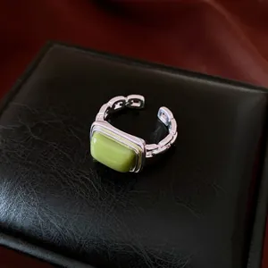 Elegant silver-toned open ring featuring a rectangular green resin gemstone centerpiece