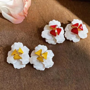 Elegante Blumenstecker mit weißen Emaille-Blütenblättern und roten oder gelben Mitten