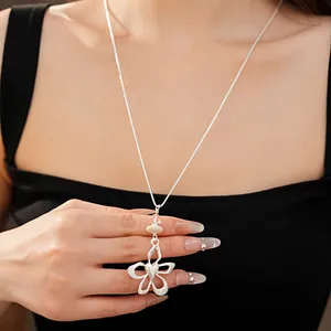 Close-up of elegant silver floral pendant necklace worn by a model on a black top