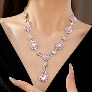 Close-up of an elegant pink gemstone necklace on a model with white crystal accents