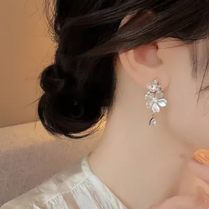 Detailed view of elegant floral drop earrings featuring a shimmering zircon teardrop