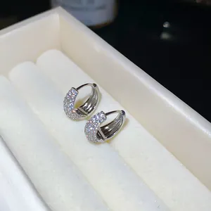 Detailweergave van elegante zilverkleurige oorringen met sprankelende zirkoniasteentjes
