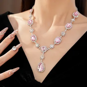 Detailed close-up view of a luxury pink crystal necklace with teardrop pendant on a model