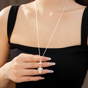 Detail view of an elegant long sweater chain necklace with pinecone and bead pendant