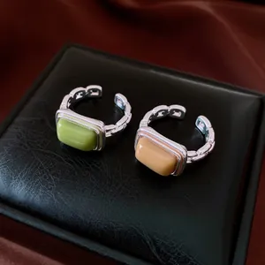 Detailed view of geometric square resin rings featuring adjustable silver chain bands