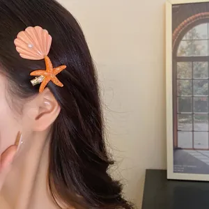 Sweet beach style seashell and starfish hair clip with pearl accents on model