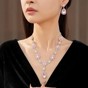 Detailed view of an elegant pink water drop crystal necklace and earring jewelry set on a model