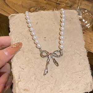 Elegante Perlenkette im französischen Stil mit einem silbernen Schleifenanhänger