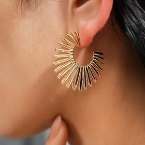 Close-up view of gold vintage C-shaped hoop earrings with unique sunburst texture