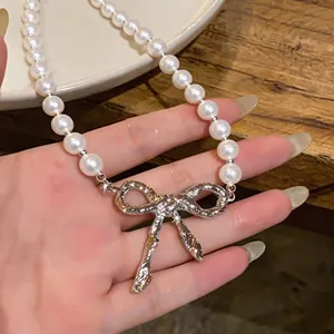 Französische Retro-Perlenkette mit einem strukturierten silbernen Schleifenanhänger