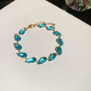 Elegante pulsera bañada en oro de 18k con vibrantes zirconitas azules en gota