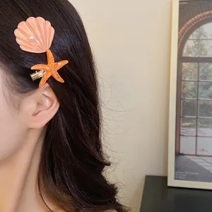 Detailed macro shot of elegant pearl shell and starfish hair clips worn by a woman