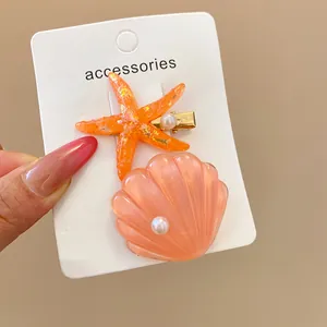 Close-up detail of cute resin shell and starfish hair clips with elegant pearl accents