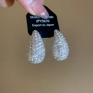Macro view showing the intricate sparkle of these silver water drop zircon earrings.