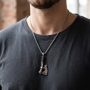 Detailaufnahme einer Wikinger-Axt-Halskette an einem männlichen Model mit grauem Shirt.