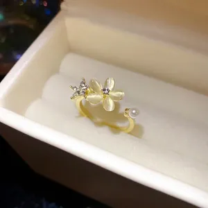 Elegante anello aperto dorato con un fiore in occhio di gatto e un accento di perla