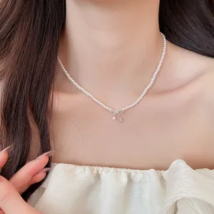 Elegante Perlenhalskette im koreanischen Stil mit filigranem Schleifenanhänger am Hals