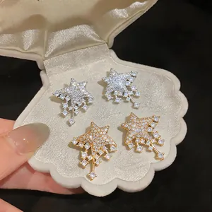Macro detail view of sparkling full-diamond star earrings in gold and silver finishes.