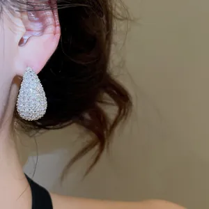 Detail view of silver teardrop stud earrings encrusted with sparkling cubic zirconia