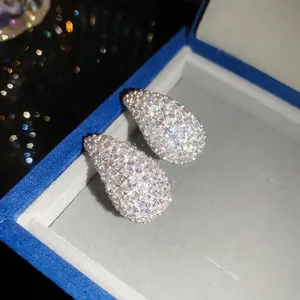 Close-up of sparkling waterdrop-shaped zircon stud earrings in a blue jewelry box