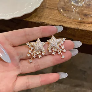 Detailed macro view of gold-toned star stud earrings with sparkling cubic zirconia pavé