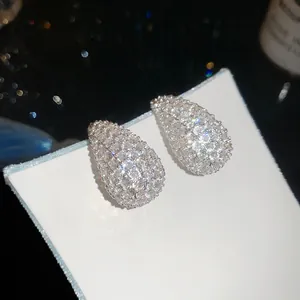 Detailed macro view of teardrop stud earrings paved with sparkling cubic zirconia