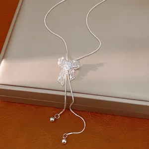Elegant silver hollow bow necklace with adjustable snake chain on jewelry display