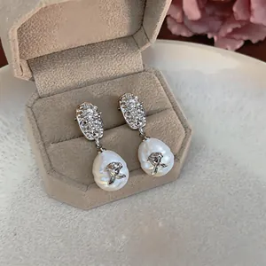 Detailed view of vintage baroque pearl drop earrings with elegant rose metal accents