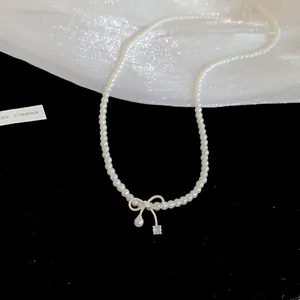 Detaillierte Nahaufnahme einer eleganten Perlenhalskette mit zierlicher Schleife und Kristall