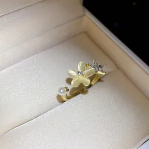 Dettaglio di un elegante anello dorato con pietra occhio di gatto e perle.