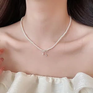 Elegante Perlenhalskette mit Schleifenanhänger an einem Model, zeigt feine Details
