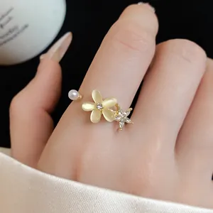 Primo piano dettagliato di un anello a fiore in oro con strass e perle luccicanti