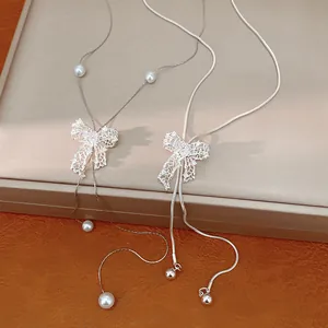 Detail view of silver hollow bow necklaces with sparkling crystal embellishments