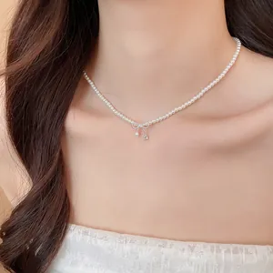 Detailansicht einer eleganten Perlenkette mit einem zarten Schleifenanhänger