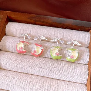 Elegant enamel apple stud earrings with sparkling zircon accents in a gift box showcase