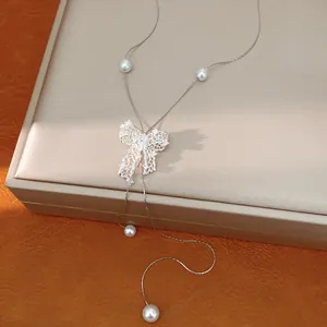 Close-up of elegant silver hollow bow necklace with integrated pearl accents
