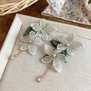 Detail of forest style flower earrings with pearls and iridescent waterdrop beads