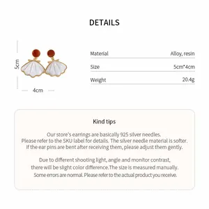 Detail view of beach style seashell earrings with material and size specifications.