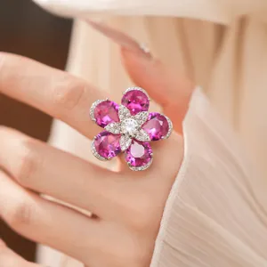 Close-up of elegant 18k gold plated flower ring with pink cubic zirconia on a hand