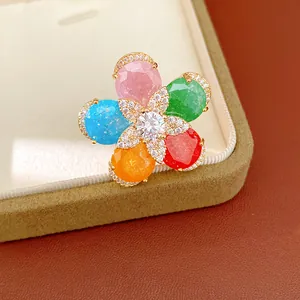 Close-up of a 18k gold plated open ring featuring a vibrant colorful flower with zircon details
