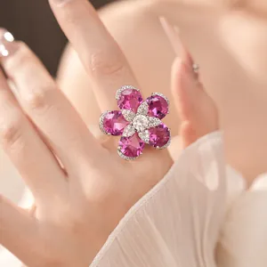 Close-up of an elegant 18k gold plated flower ring with pink zircons on a hand