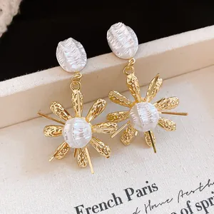 Close-up of French vintage gold earrings with textured pearl flower design