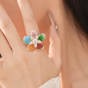 Detailed shot of an 18k gold plated flower ring with colorful zircons on a finger