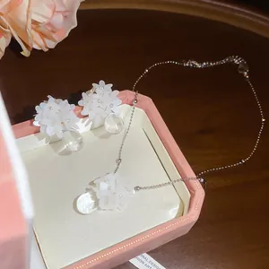 Detail of resin flower and water-drop pendant necklace and earring set in gift box.