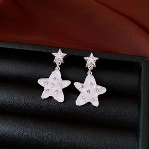 Elegant star earrings with mother-of-pearl inlay and rhinestones on silver studs.