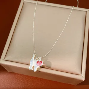 Vista dettagliata del ciondolo gatto in madreperla e cuore rosso su collana argento