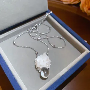 Close-up of French style flower pendant necklace with clear resin water drop detail