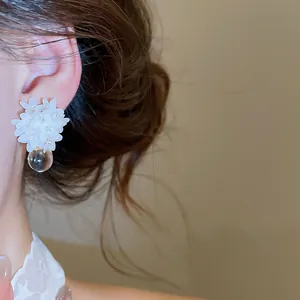 Close-up of elegant French resin flower earrings with clear drop pendant detail